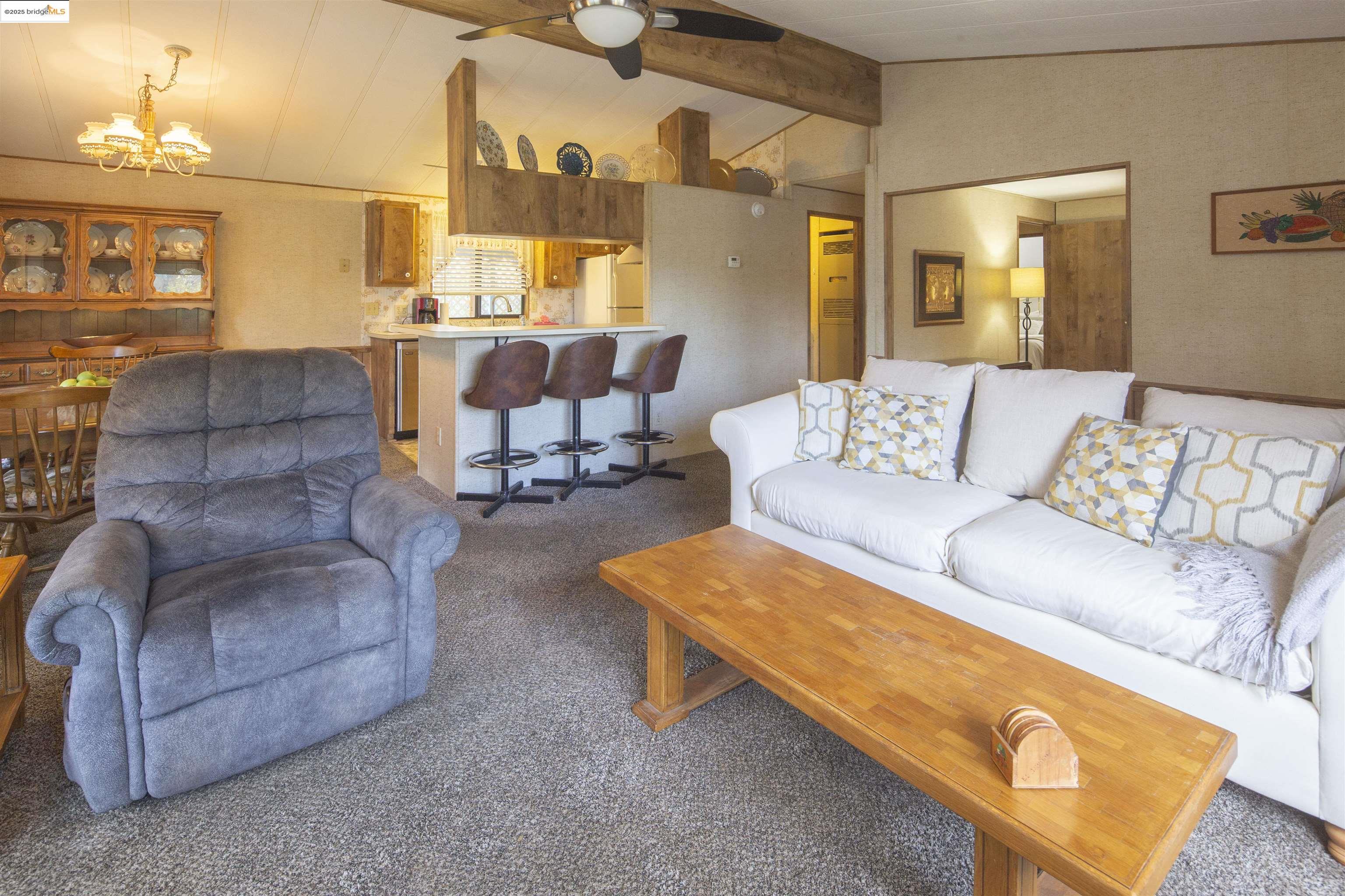 18717 Mill Villa Road, Unit 156 Jamestown, CA 95327 - Photo 12 of 40 Carpeted living room with a chandelier and a ceiling fan