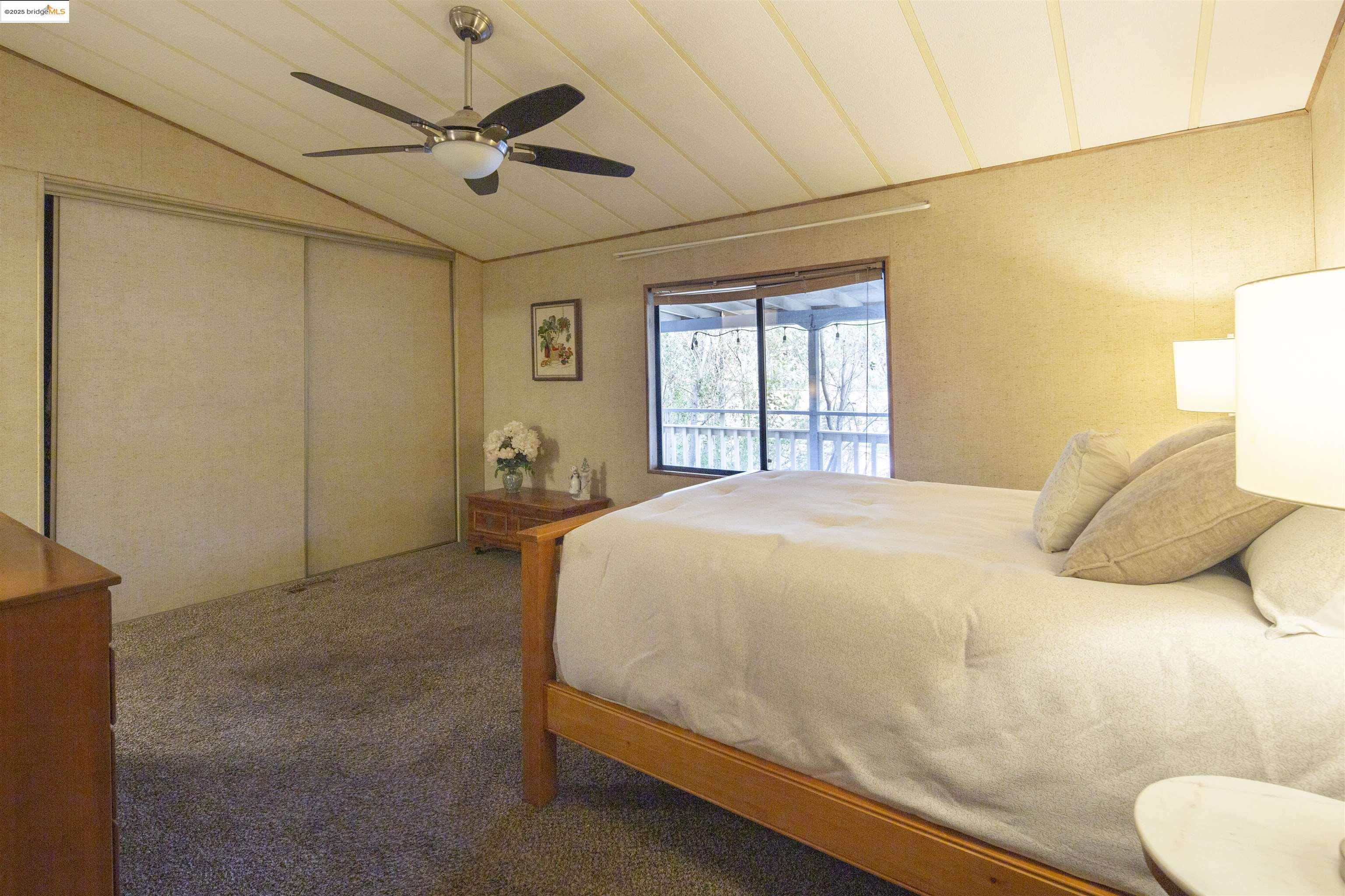 18717 Mill Villa Road, Unit 156 Jamestown, CA 95327 - Photo 15 of 40 Carpeted bedroom with lofted ceiling, access to outside, a closet, and a ceiling fan