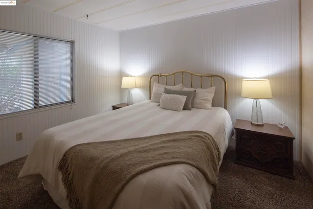 a large bed sitting in a bedroom next to a lamp