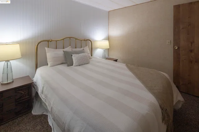 a spacious bedroom with a bed and a lamp