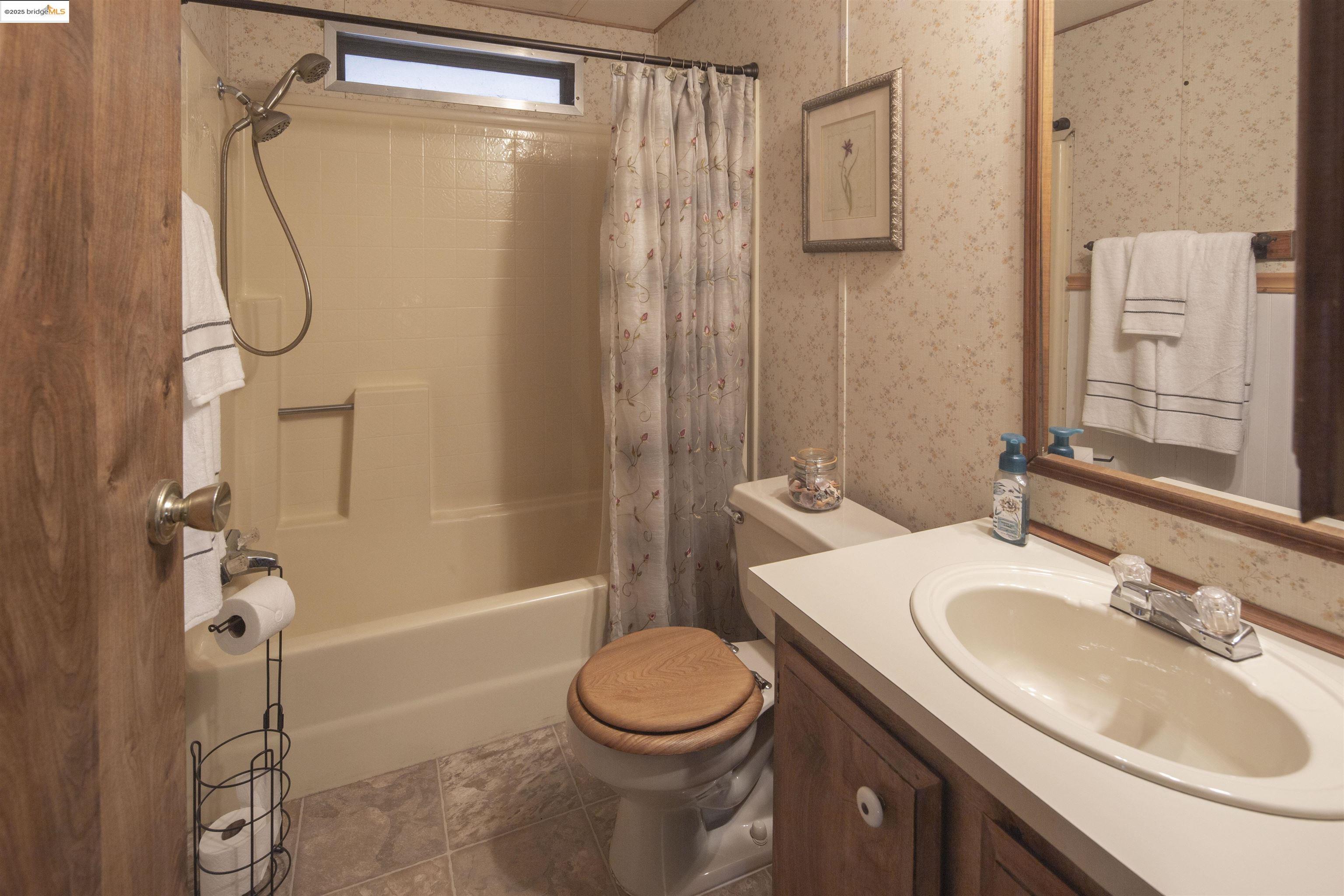 18717 Mill Villa Road, Unit 156 Jamestown, CA 95327 - Photo 20 of 40 Bathroom with vanity, shower / tub combo with curtain, wallpapered walls, and tile patterned floors