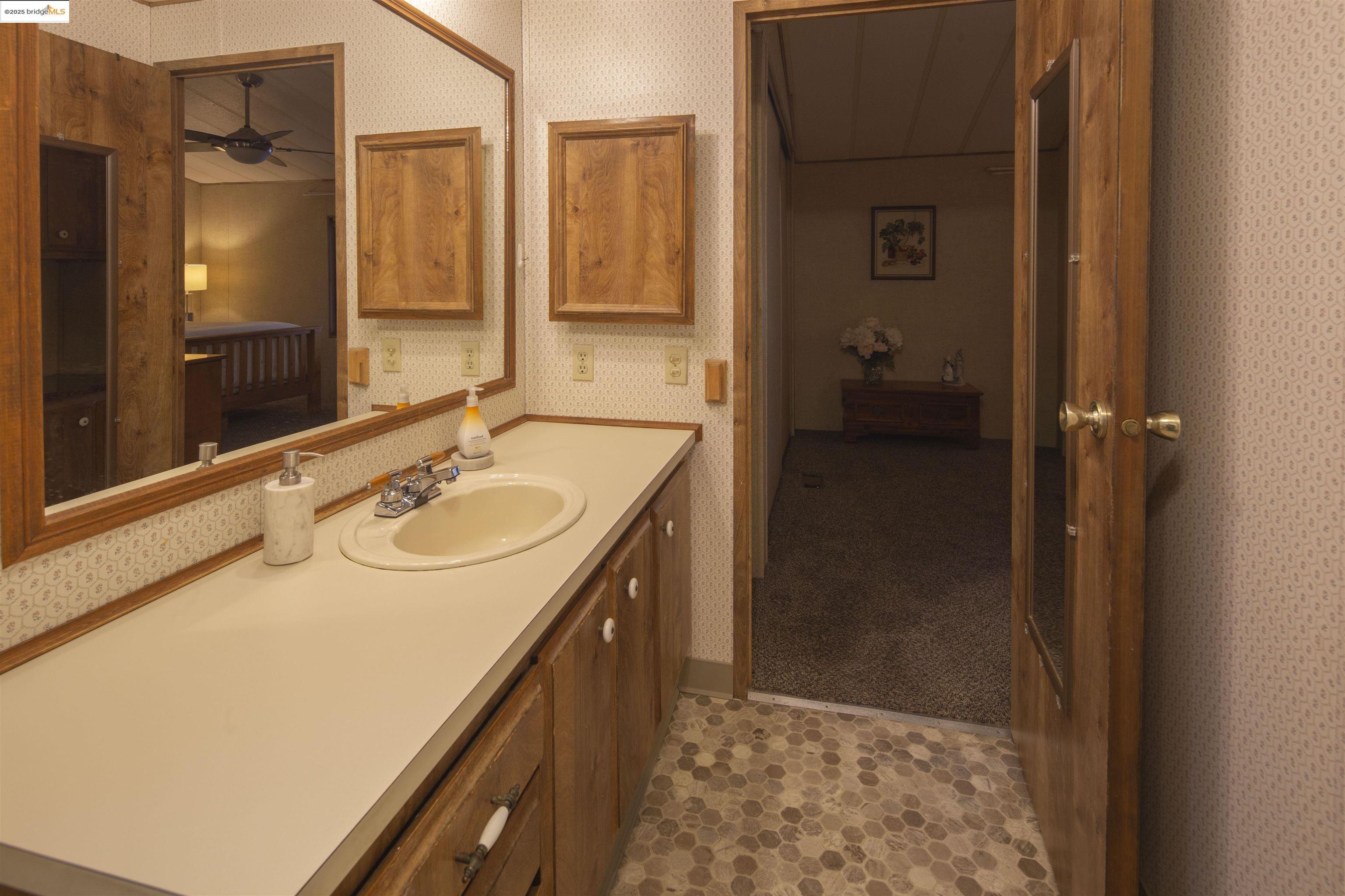 18717 Mill Villa Road, Unit 156 Jamestown, CA 95327 - Photo 21 of 40 Bathroom with wallpapered walls and vanity