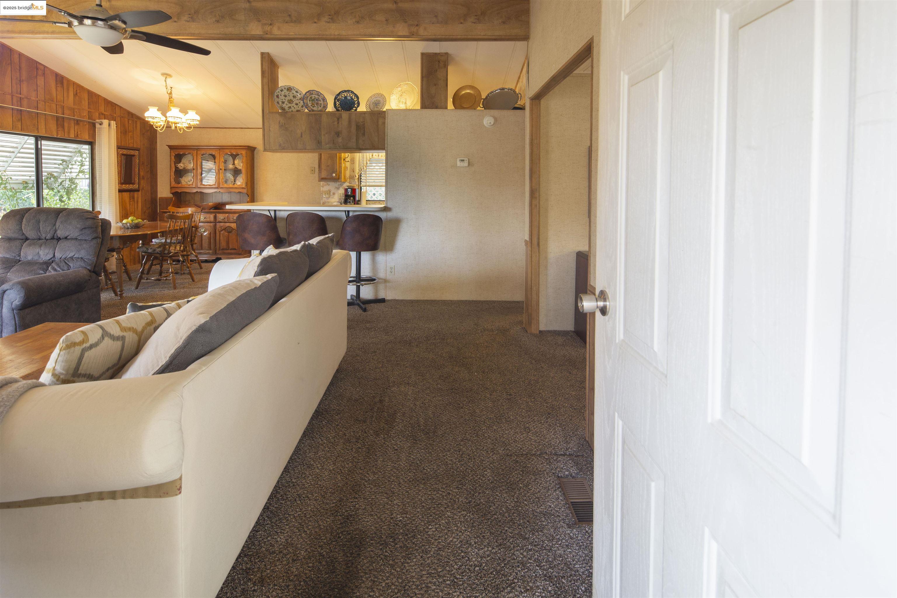 18717 Mill Villa Road, Unit 156 Jamestown, CA 95327 - Photo 8 of 40 Carpeted living area featuring a ceiling fan and a chandelier