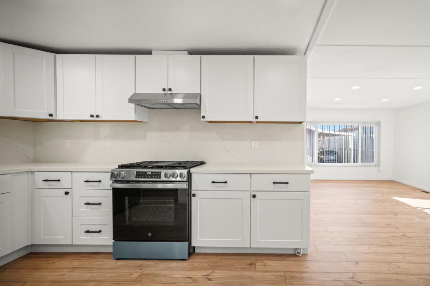 55 San Juan Grade Road, Unit 63 Salinas, CA 93906 - Photo 35 of 37 a kitchen with white cabinets and a stove with wooden floor