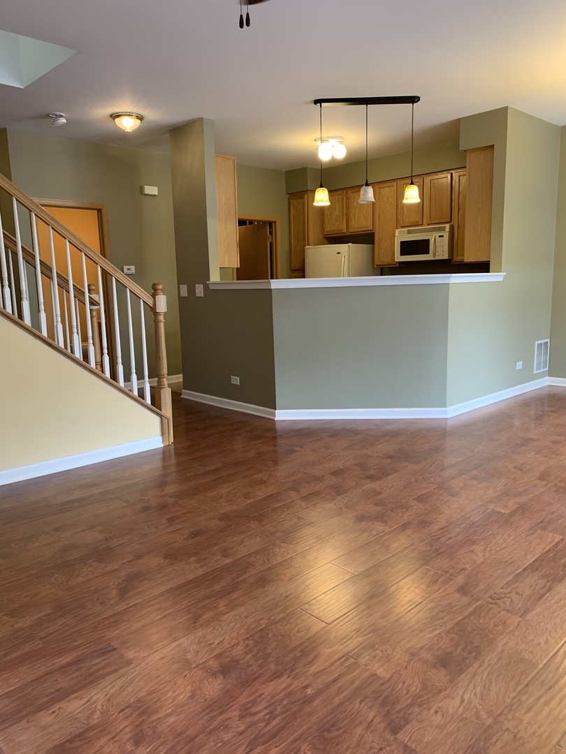1944 Crestview Circle Romeoville, IL 60446 - Photo 3 of 35 an empty room with wooden floor and a mirror