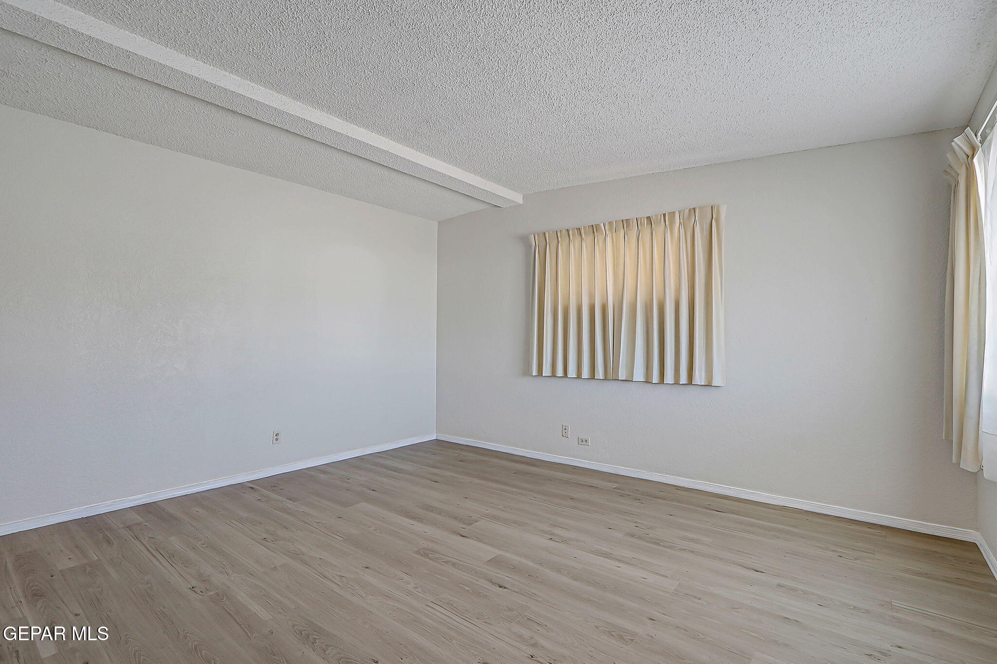 7906 Santa Maria Road El Paso, TX 79915 - Photo 7 of 26 wooden floor in an empty room with a window