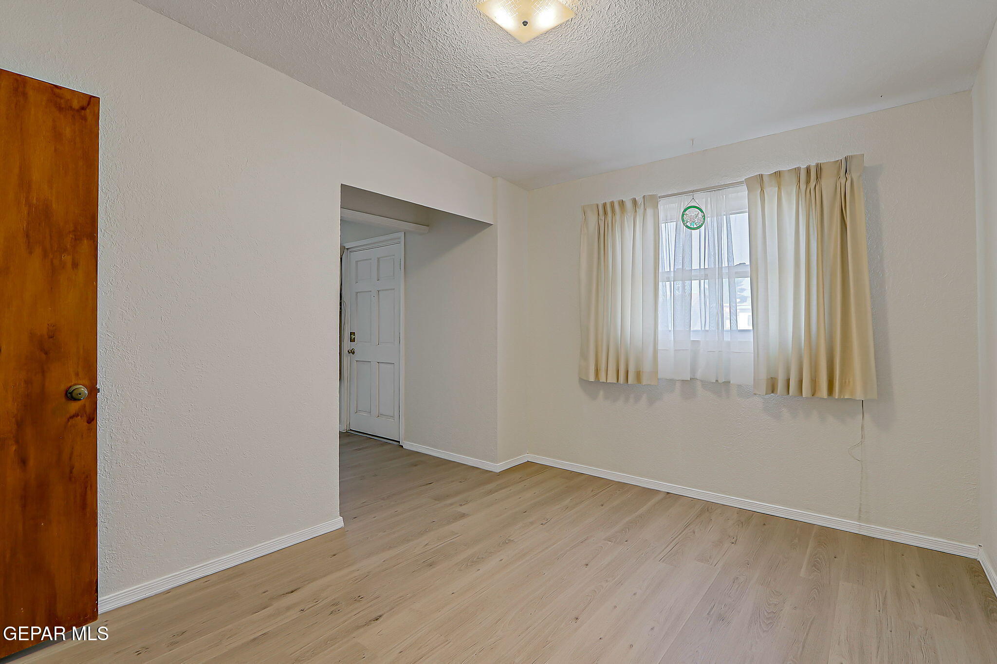 7906 Santa Maria Road El Paso, TX 79915 - Photo 8 of 26 a view of an empty room with wooden floor and a window
