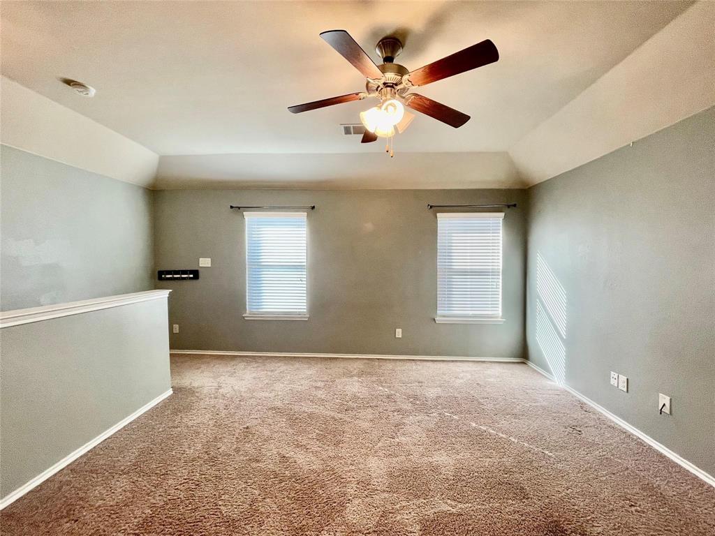 1005 Lake Woodland Drive Little Elm, TX 75068 - Photo 13 of 37 Carpeted spare room with lofted ceiling and a ceiling fan