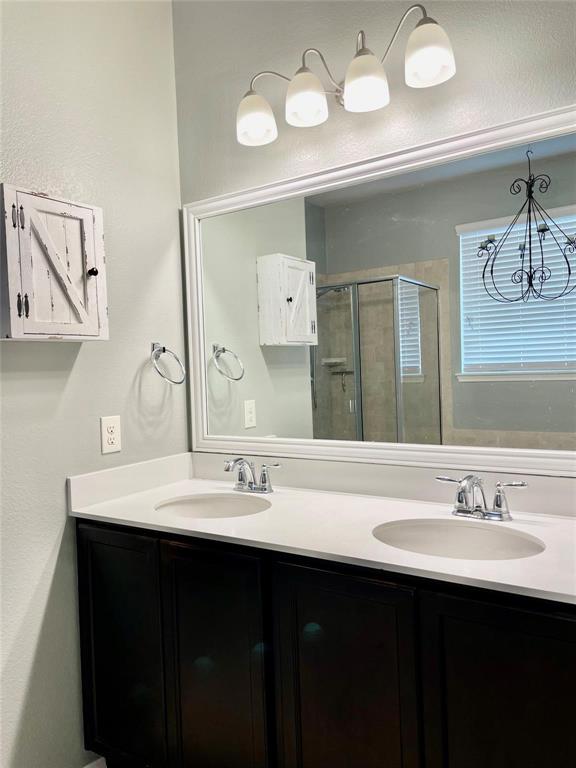 1005 Lake Woodland Drive Little Elm, TX 75068 - Photo 19 of 37 Full bath with a stall shower, double vanity, and a textured wall