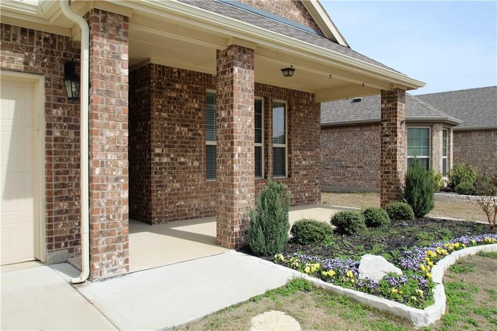 1005 Lake Woodland Drive Little Elm, TX 75068 - Photo 2 of 37 View of exterior entry with brick siding, a shingled roof, and a patio area