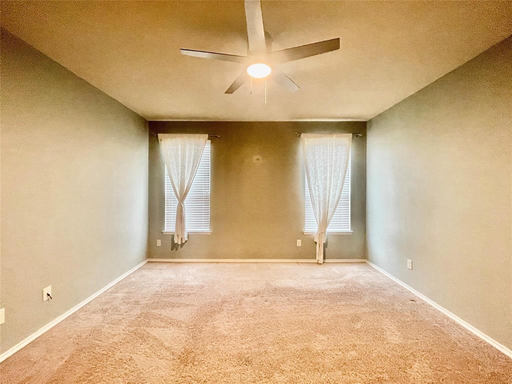 1005 Lake Woodland Drive Little Elm, TX 75068 - Photo 22 of 37 Empty room featuring carpet flooring, healthy amount of natural light, a ceiling fan, and a textured ceiling