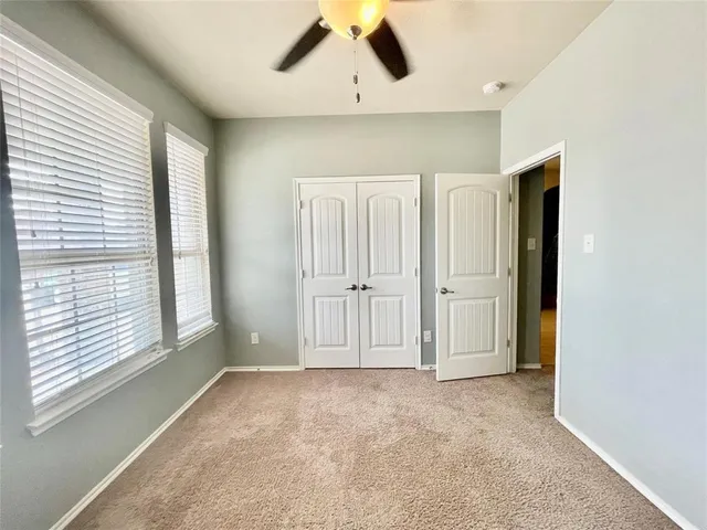 an empty room with windows and cabinet