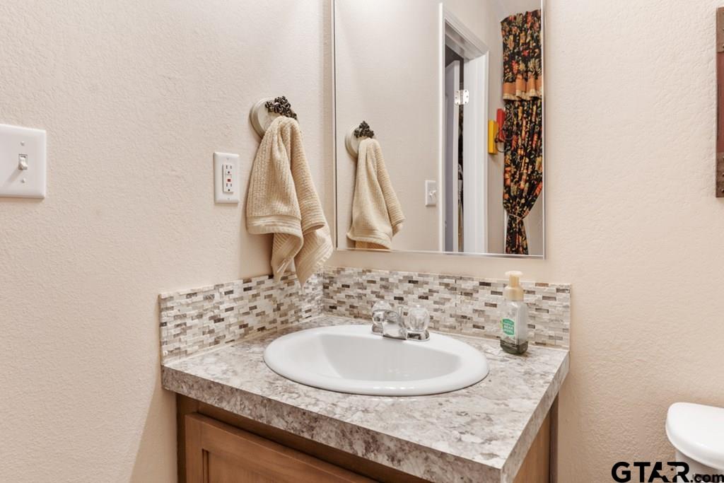 12350 County Road 2911 Eustace, TX 75124 - Photo 31 of 43 a bathroom with a granite countertop sink and a mirror