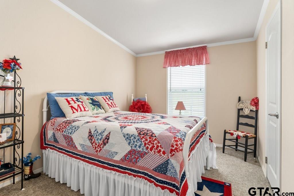 12350 County Road 2911 Eustace, TX 75124 - Photo 33 of 43 a bedroom with a bed and a chandelier