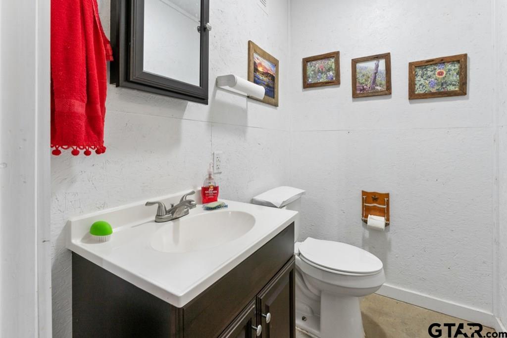 12350 County Road 2911 Eustace, TX 75124 - Photo 41 of 43 a bathroom with a sink a toilet and vanity