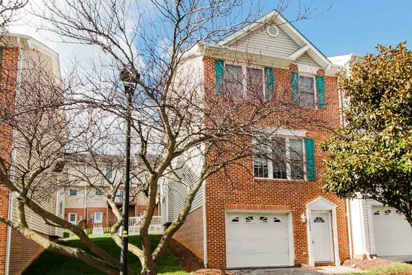a view of a white house with a large tree