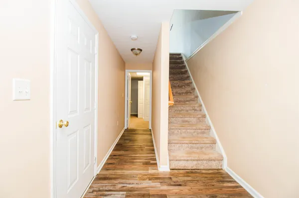 a view of a hallway with wooden floor and entryway