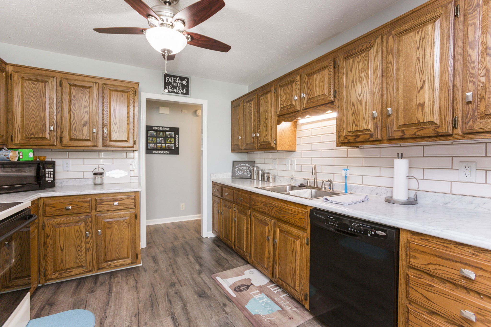 6045 Ebenezer Road Greenbrier, TN 37073 - Photo 10 of 30 a kitchen with stainless steel appliances granite countertop wooden cabinets a stove a sink and dishwasher with wooden floor