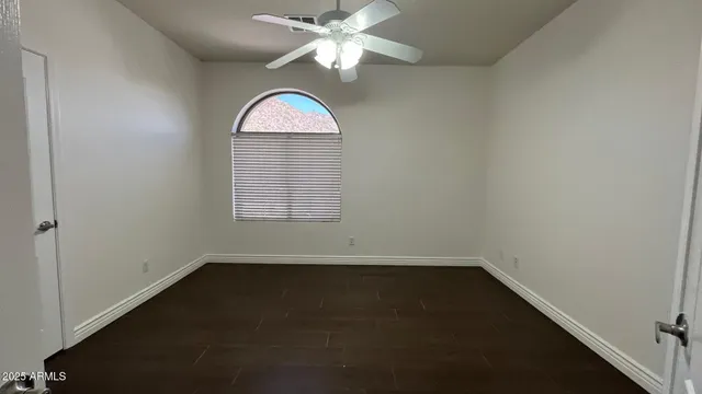 an empty room with windows and fan