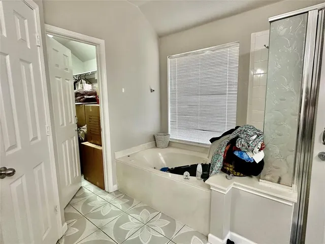 a bathroom with a tub sink and mirror