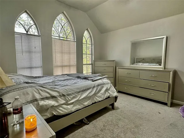 a bed sitting in a bedroom next to a window