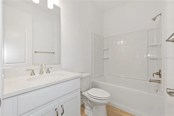 a bathroom with a sink toilet vanity and shower