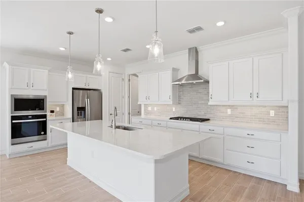 a kitchen with stainless steel appliances a stove a sink and a refrigerator