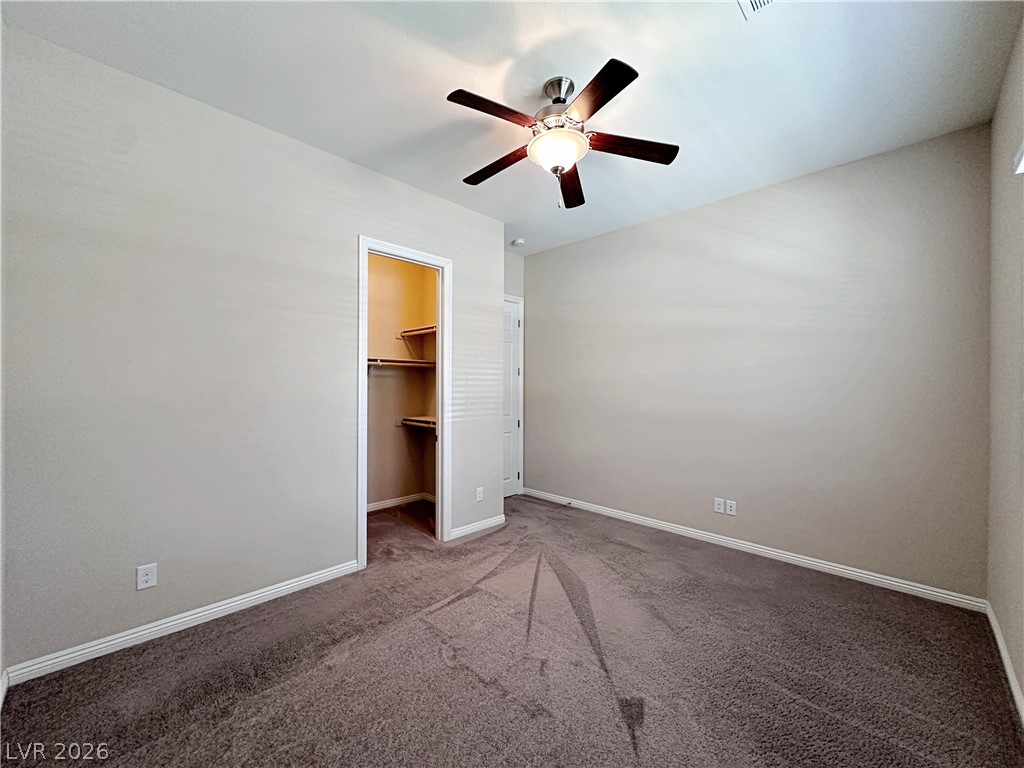 71 Newton Ridge Way Las Vegas, NV 89183 - Photo 20 of 40 A restful bedroom offers ample closet space and a cooling ceiling fan.