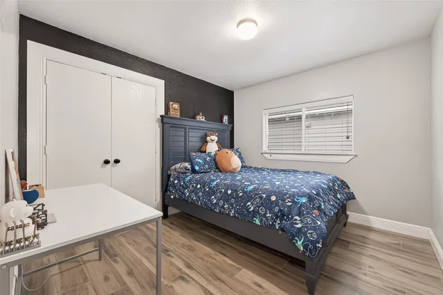 a bedroom with a bed and wooden floor