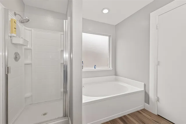 a white bath tub sitting next to a shower