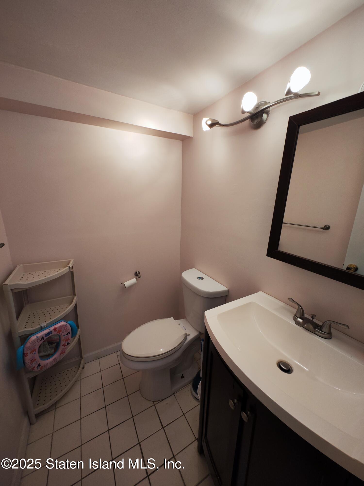 517 Rathbun Avenue Staten Island, NY 10312 - Photo 22 of 28 a bathroom with a sink toilet and mirror