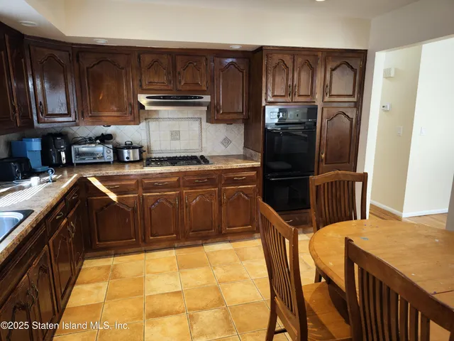 a kitchen with granite countertop a refrigerator and a stove top oven