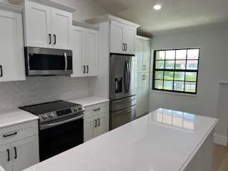 a kitchen with stainless steel appliances a stove microwave and refrigerator