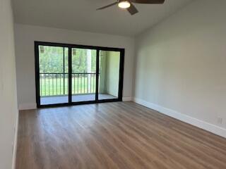 102 Pinecrest Circle, Unit C Jupiter, FL 33458 - Photo 14 of 38 an empty room with wooden floor and windows