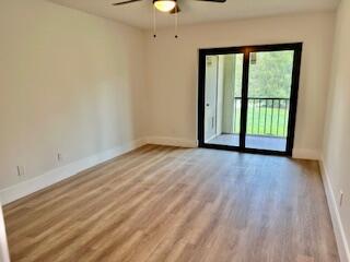 102 Pinecrest Circle, Unit C Jupiter, FL 33458 - Photo 18 of 38 wooden floor in an empty room with a window