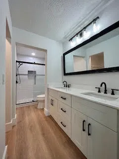 a bathroom with a double vanity sink mirror and shower