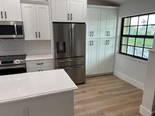 102 Pinecrest Circle, Unit C Jupiter, FL 33458 - Photo 4 of 38 a kitchen with a refrigerator and a stove