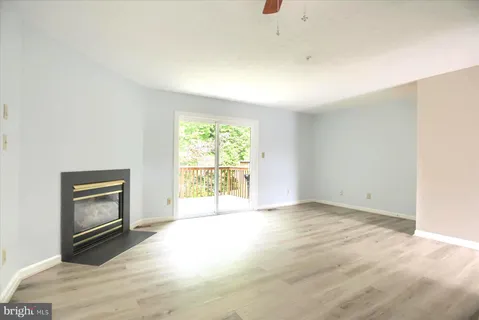a view of an empty room with a window and a fireplace