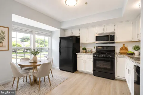a kitchen with a stove a refrigerator and a dining table