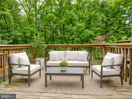 a balcony with wooden floor and outdoor seating