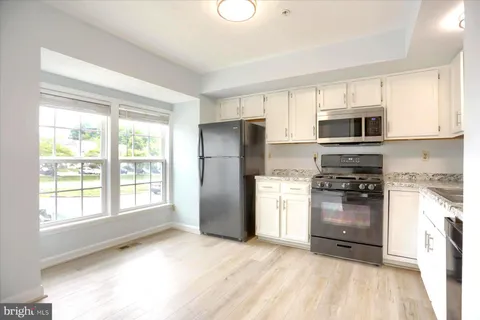 a kitchen with a refrigerator and a stove top oven