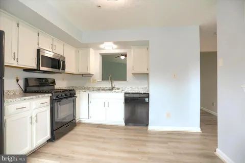 a kitchen with a sink and steel appliances