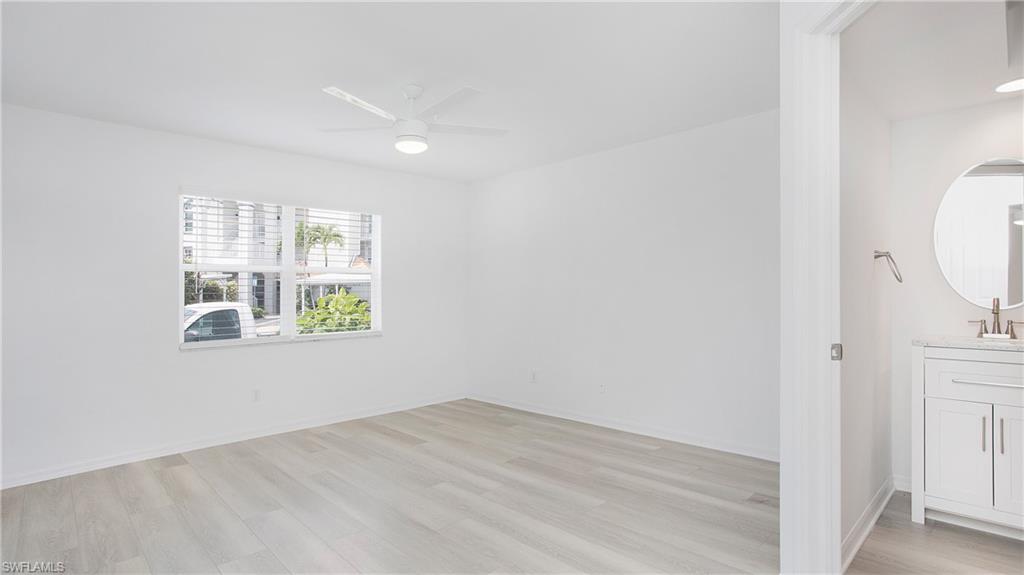 470 Bermuda Cove Way, Unit 2104 Naples, FL 34110 - Photo 13 of 35 Primary bedroom featuring light wood-style flooring, ceiling fan, a sink, and baseboards
