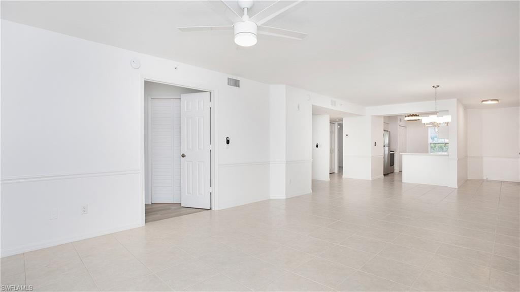 470 Bermuda Cove Way, Unit 2104 Naples, FL 34110 - Photo 24 of 35 Empty room with a chandelier, ceiling fan, and light tile patterned flooring
