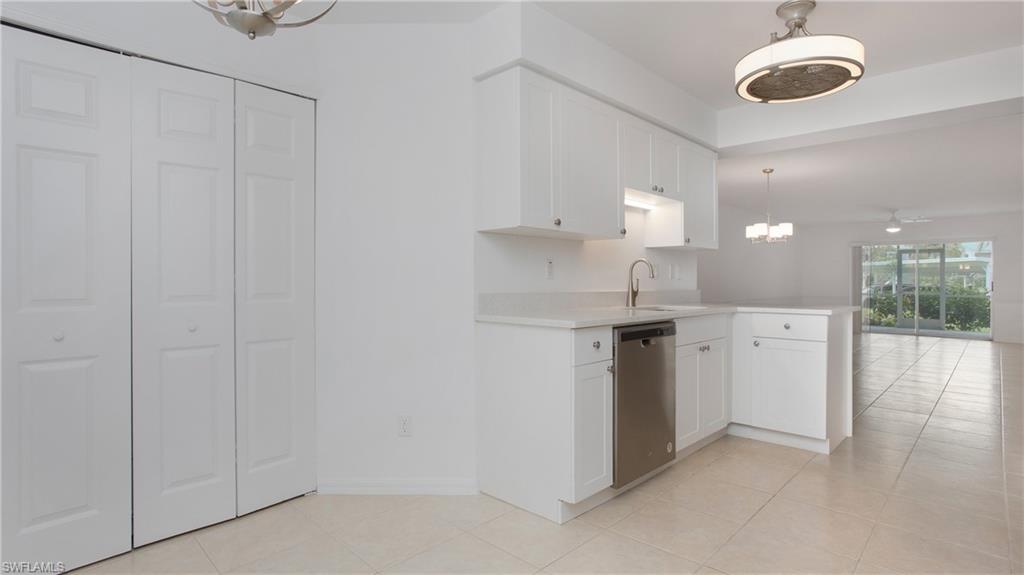 470 Bermuda Cove Way, Unit 2104 Naples, FL 34110 - Photo 9 of 35 Kitchen featuring dishwasher, a chandelier, a sink, light countertops, and light tile patterned flooring