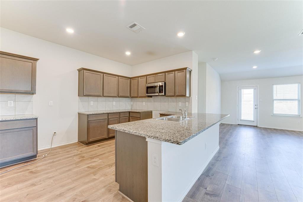 517 Milo Way Royse City, TX 75189 - Photo 3 of 34 Kitchen featuring wood-finish flooring, recessed lighting, and a peninsula island with an undermount double-basin sink