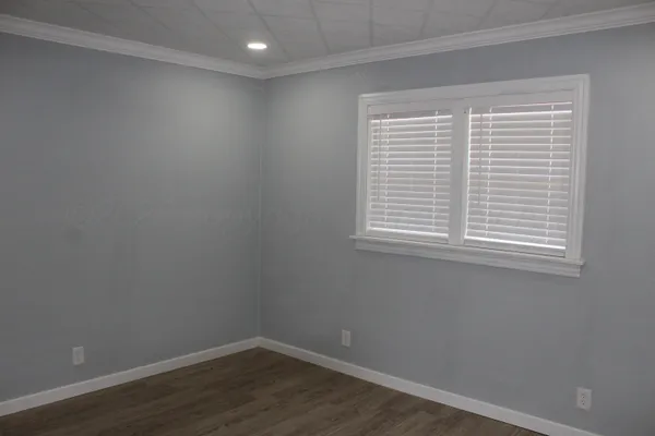 a view of a small space with wooden floor and a window
