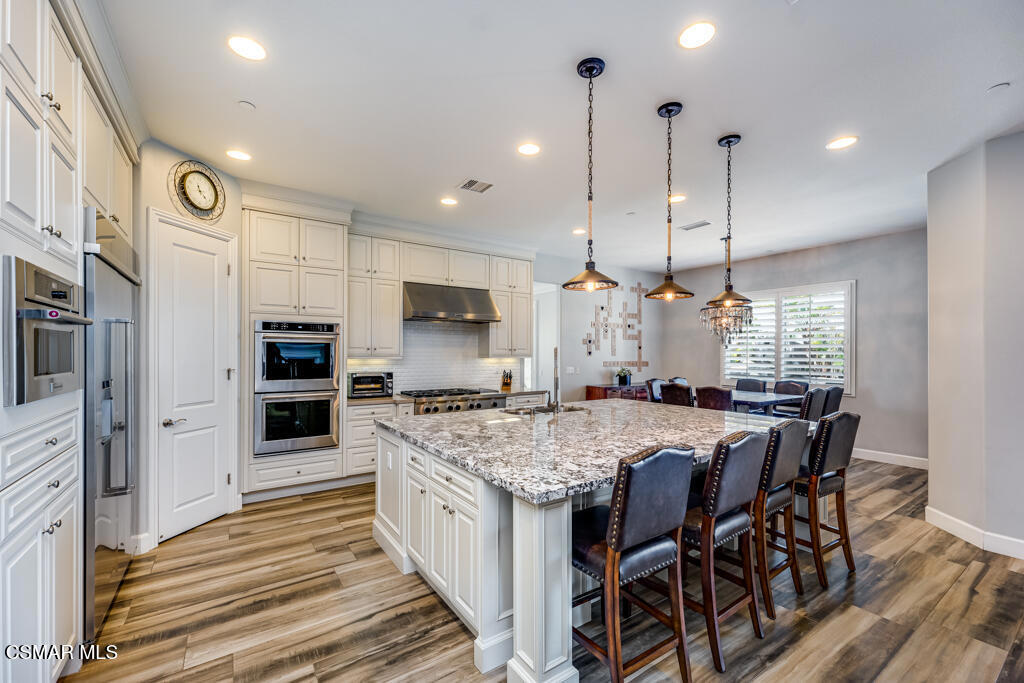 7377 Woods Court Moorpark, CA 93021 - Photo 5 of 29 a kitchen with stainless steel appliances granite countertop a kitchen island a stove and a refrigerator
