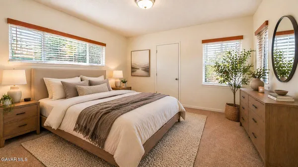 a bedroom with a bed a dresser next to a window