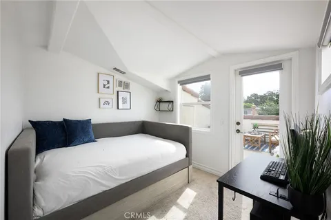 a bedroom with a large bed and a potted plant